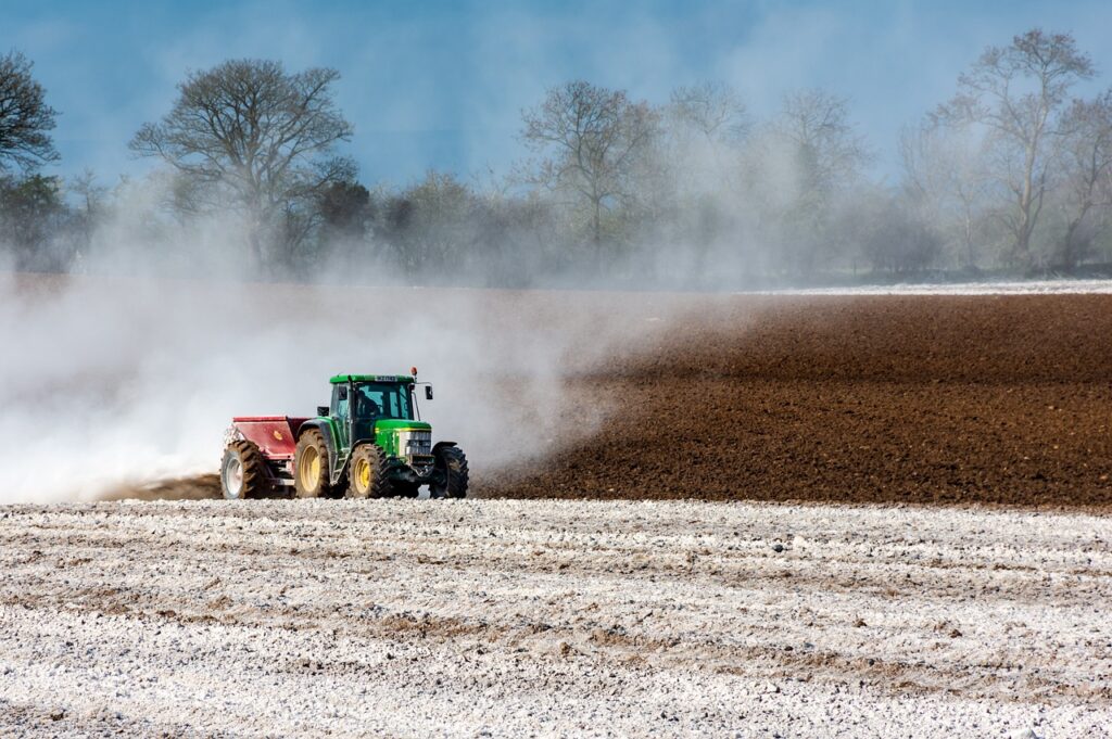 Farmer spreading fertiliser in a field