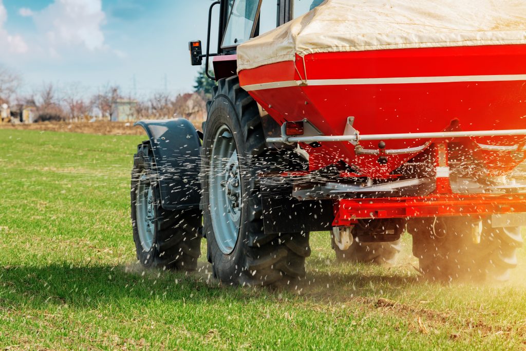 Tractor spreading fertiliser in a field