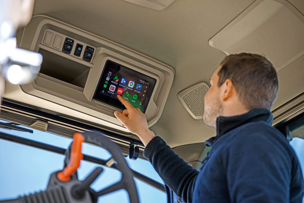 Agricultural operator using Apple Carplay system inside new John Deere 8R 410